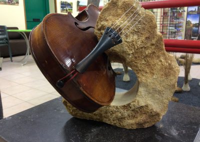Un violon encastré dans une pierre maintenue par ces cordes