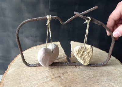 Deux coeurs de pierre suspendue dans un cadre fait d'un vieux fil de fer