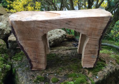 Un tabouret fait de bois quasi brut en forme de petite table