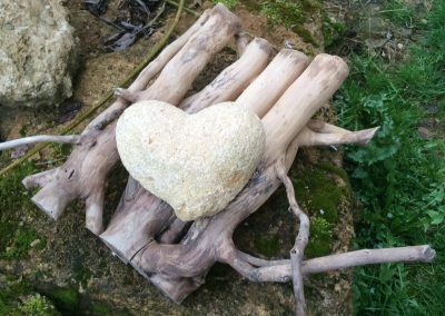 Cœur en pierre sur un petit radeau fait de vieux bois