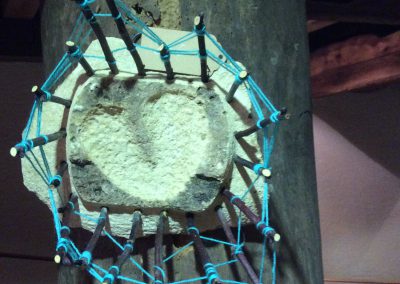 Montage d'une pierre foncé taillée en son centre un coeur le tout entouré d'une petite cloture avec de la corde bleu