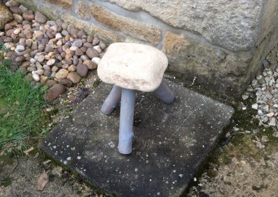 Un tabouret en pierre avec des pieds de bois