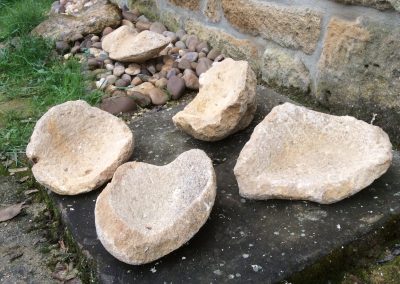 Plusieurs pierres taillées en bol sur une plus grosse pierre noir