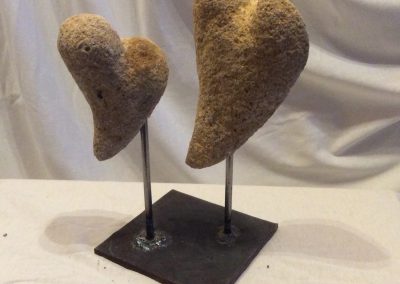 Deux coeurs de pierres maintenus par un support en fer noir