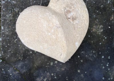 Gros coeur en pierre posé sur une vieille pierre sombre