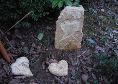 Deux pierres en forme de coeurs et une grosse pierre ou est directement taillé un coeur et un oxo