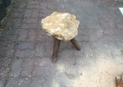 Un tabouret de pierre avec des pieds en bois