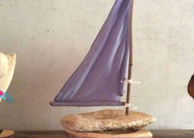 Un bateau de pierre avec une voile blue et blanc
