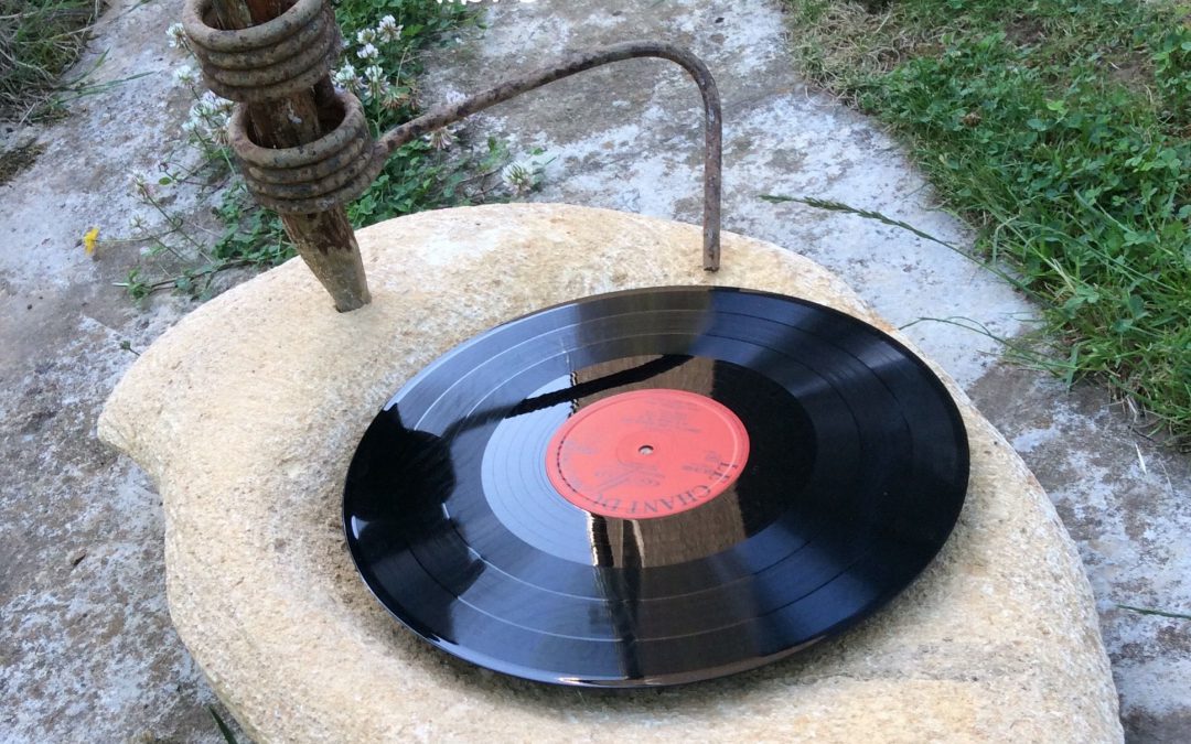 Un faux tournedisque fait de pierre et de bois avec un disque posé dessus