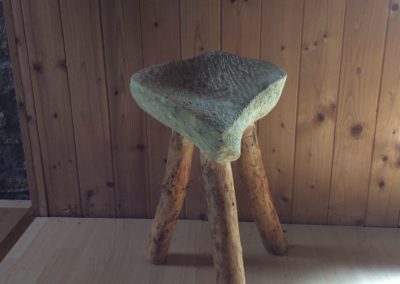 Un tabouret de pierre avec des pieds en bois