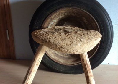 Un tabouret de pierre avec des pieds en bois